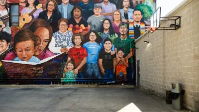A mural on a wall behind a basketball court, showing many people.