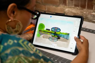 Delilah Salgado shows a mockup of the project on a tablet