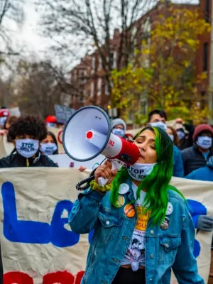 two people with bullhorns lead a group of marching protesters