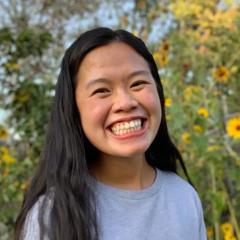Portrait of a person standing in front of sunflowers