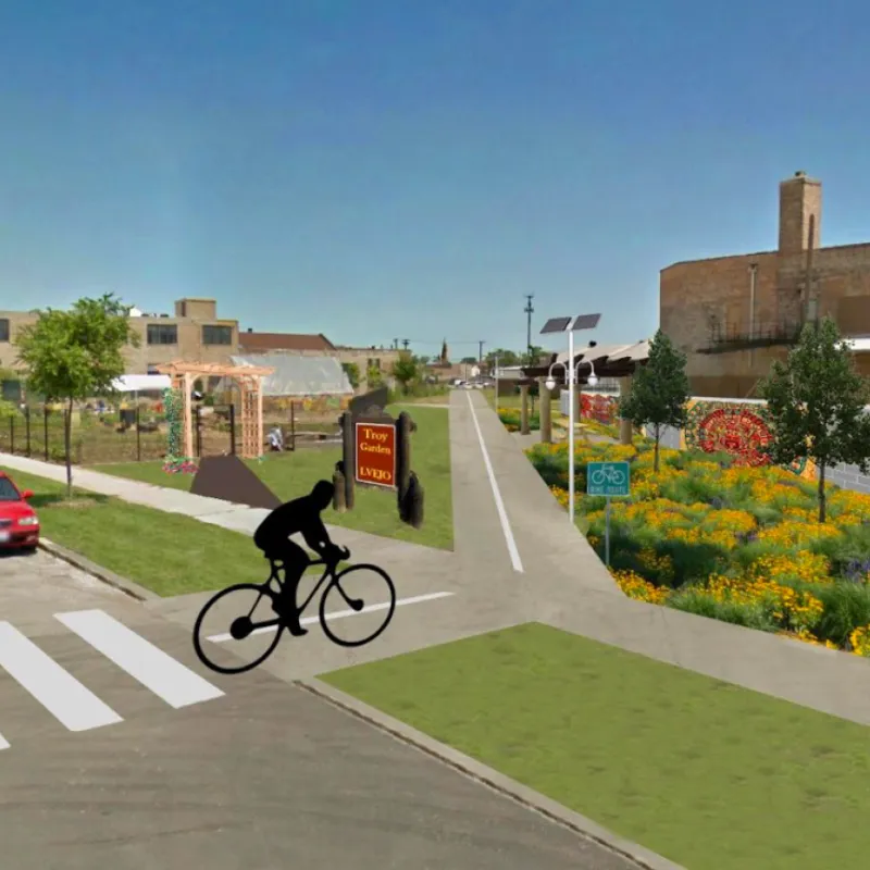 rendering shows a bike path that runs alongside a garden, lush landscaping, and murals amid an industrial landscape