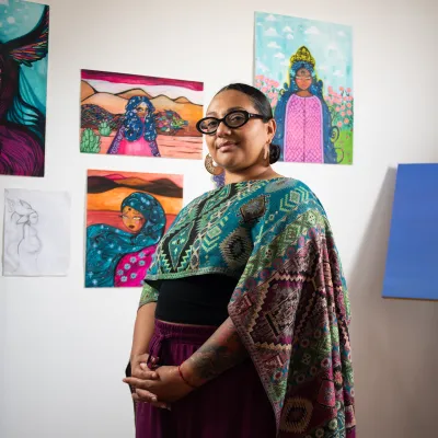 Delilah Salgado in her studio in front of paintings on the wall