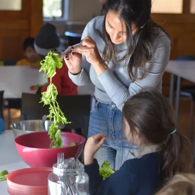 woman serving lettuce to a child 
